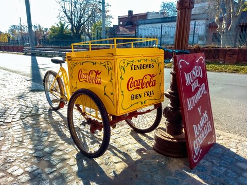 Old beverage vending cargo bike. Delivery trike. Coca Cola logo and brand with fileteado ornaments
