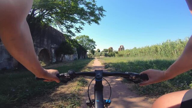 POV cyclist riding bike in aqueduct park. Rome, Italy