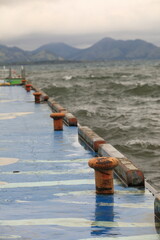 Fototapeta premium orange Rusty bollard on blue pier at inawashiro lake, Japan.