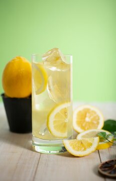 Vertical shot of sliced lemons with a glass of lemon jouce
