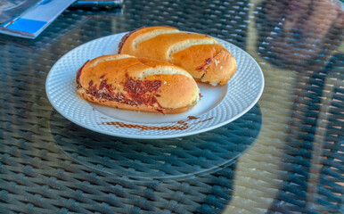 Milk bread filled with cocoa cream on a white porcelain plate