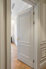 Fototapeta na wymiar vertical corner frame on part of interior with white wall ajar door and empty room, white walls and parquet wood floor