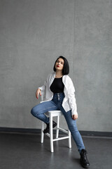 A woman in a white shirt sits on a chair