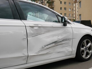 Dent on front right door white car.