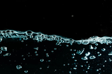 Water surface with bubbles on black background.
