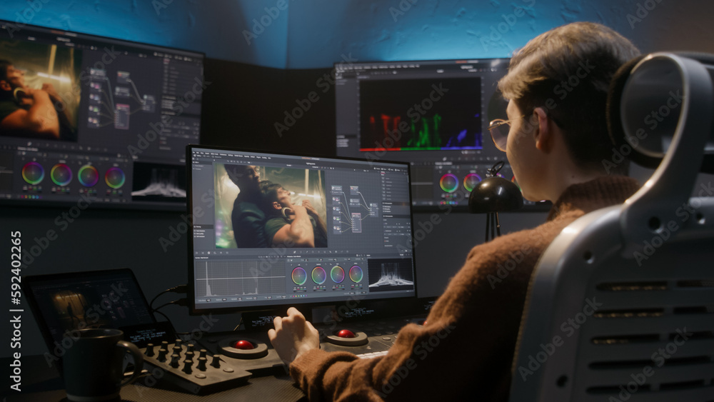 Poster the editor works in studio on computer, uses color grading control panel, edits video, makes color c