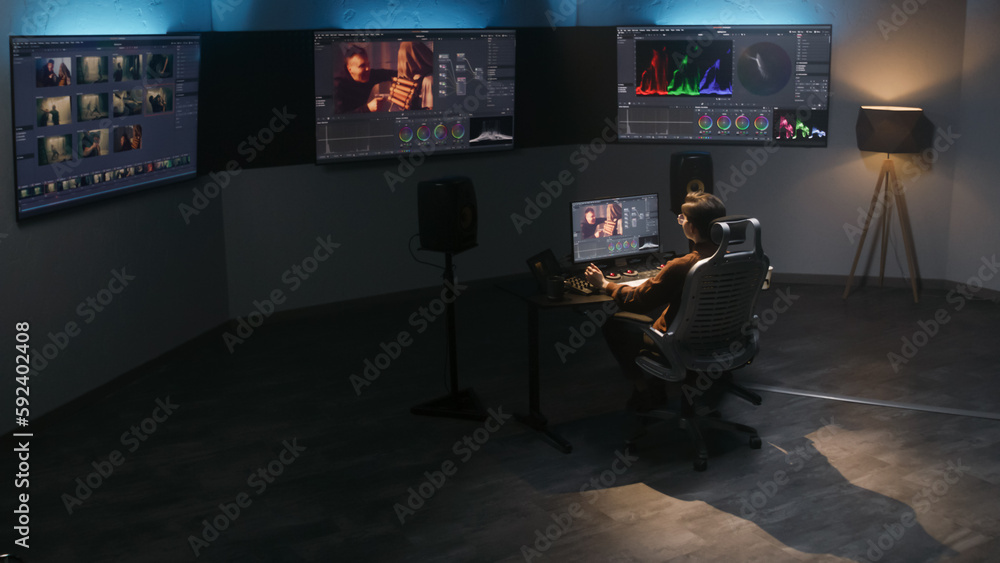 Poster the video editor works in studio on computer, uses color grading control panel, edits video, makes c