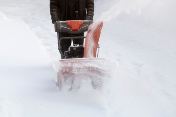 A portable snow blower powered by gasoline. Snow removal in winter.