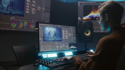 Female editor uses color grading control panel, edits video, makes movie color correction on...