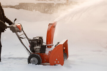 Fototapeta premium A portable snow blower powered by gasoline. Snow removal in winter.