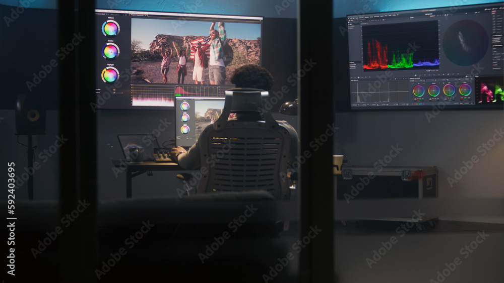 Poster african american colorist does color grading in professional software on computer. process of colour