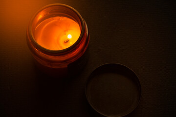 scented candle in jar dark and moody background selective focus
