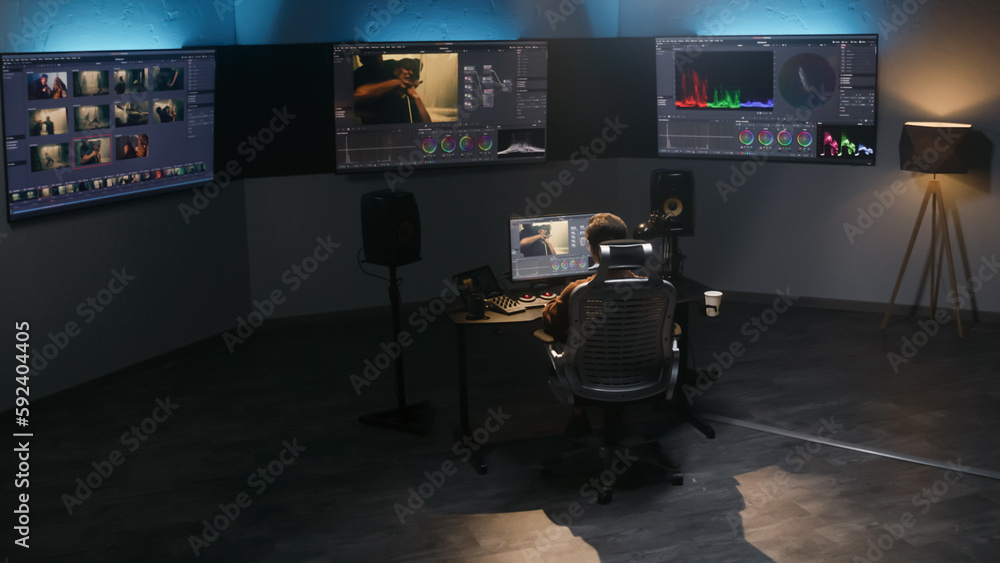 Aufkleber the video editor works in studio on computer, uses color grading control panel, edits video, makes c