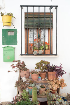 Ventana con adornos florares al sur de Espa&ntilde;a en Andaluc&iacute;a con macetas y varios buzones de correos.
