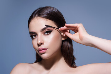 Beautiful woman with dark eyebrows hold eyebrow brush. Eyebrows lamination. Brow beauty procedures....