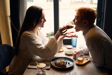 Tender young brunette feeds her friend from the hands