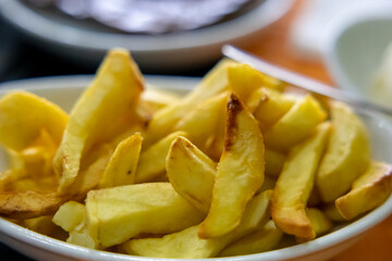 Home made fried potatoes on a plate in a restaurant. Selective focus.