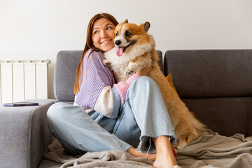 cute young woman taking care and petting her adorable corgi dog . Man's friend and Lifestyle