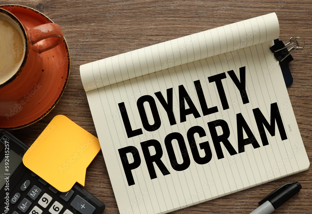 Poster loyalty program. notepad and pen and coffee on a desk. blank notepad page for entering text in the m