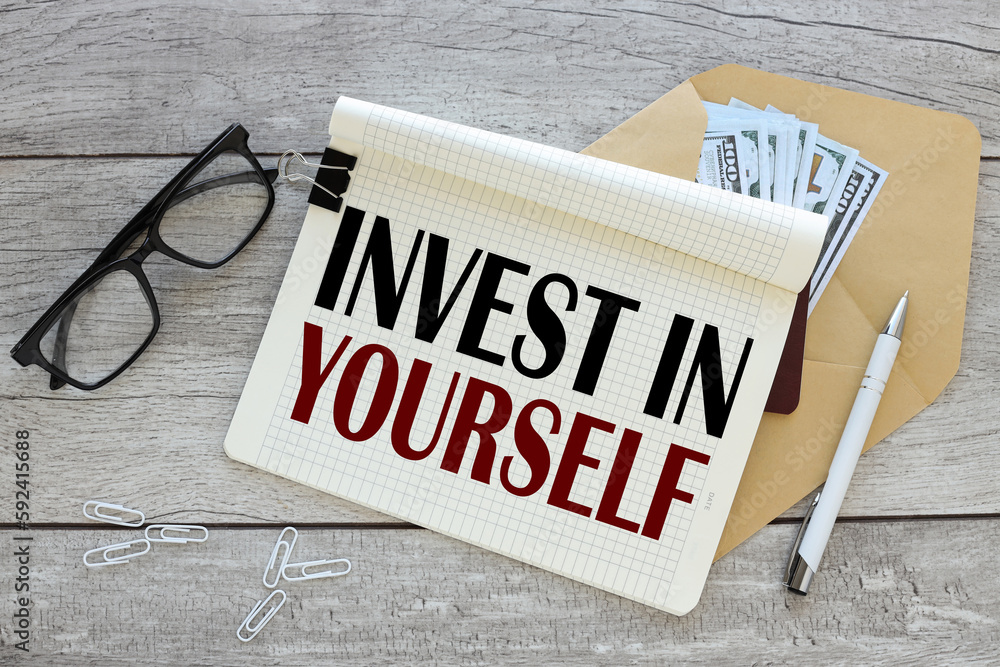 Aufkleber invest in yourself notepad with text on an envelope with banknotes