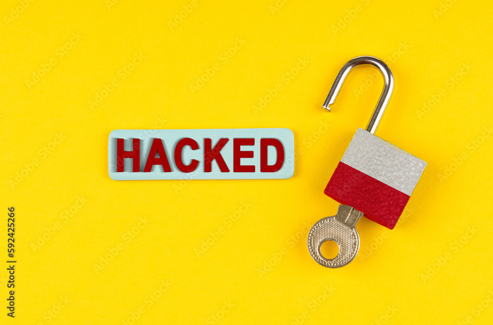 Poster On the yellow surface is an open lock with a key and a sticker with the inscription - hacked