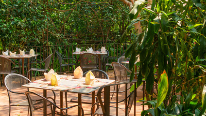 Mesas con servicio a punto del desayuno en terraza con vegetación