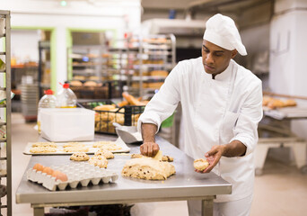 Baker at work - making sweet buns with dough and eggs