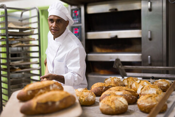 Baker pulls hot bread out of the oven