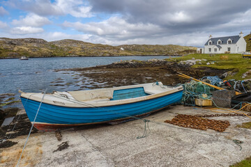 Fototapeta na wymiar Blue rowing boat and white cottage near to Flodbay on the Isle of Harris