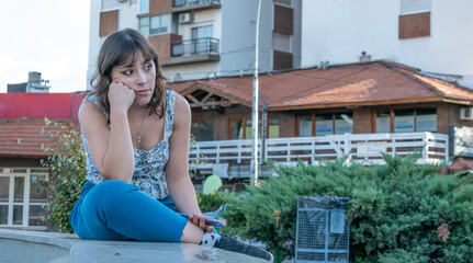 Bored woman looks at the horizon and waits for her friend. Copy Space