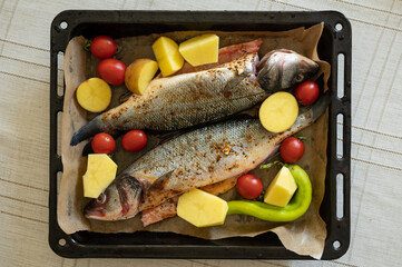 Baking pan with ready to cook sea bass fish