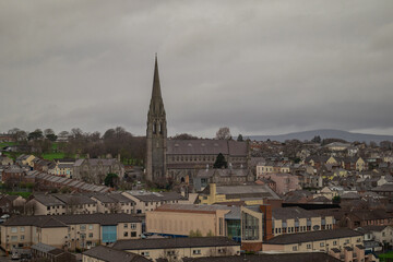 Panorama of Derry or Londonderry on a cloudy day viewed from the city walls. Green panorama of the city, church or cathedral visible.