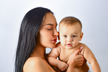 Mother hug. Closeup studio portrait of mother and baby child isolated on whtite. Mother hugging and embracing baby son. Mothers day, love family. Mother and baby child with tenderness.