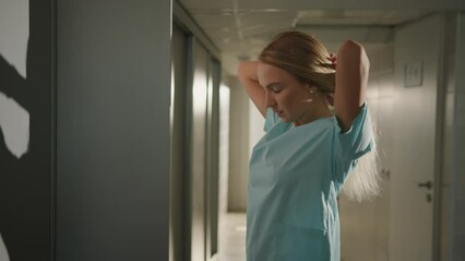 A female doctor came to work at the hospital. A young woman in the locker room is getting ready for a working day - Powered by Adobe