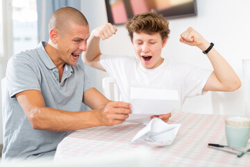 Obraz premium Happy son and father rejoice at the good news letter