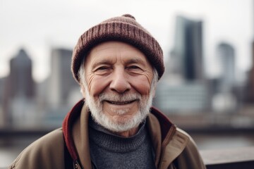 Portrait of a smiling senior man in the city. He is wearing a hat and coat.