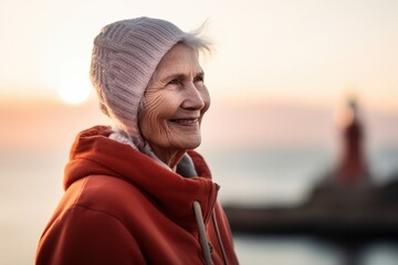 Portrait of happy senior woman in cap looking away at seaside