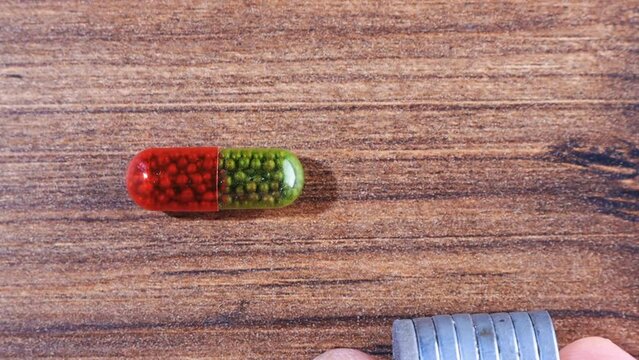 Capsule with iron, dietary supplement. Iron atoms in the supplement far from each other to build ferromagnetic domains but still stick to a magnet. Vitamin pills, pharmacy and healthy diet concept
