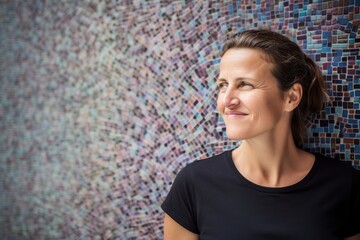 Portrait of a beautiful woman smiling against a colorful mosaic wall background