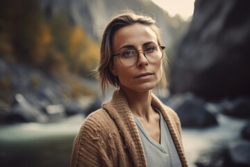 Portrait of a beautiful young woman with glasses in the mountains.