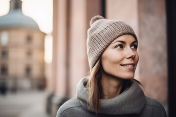 Portrait of a beautiful young woman in a hat and coat in the city
