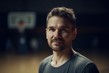 Portrait of a young man looking at camera while playing basketball.