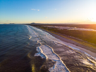 Aerial (drone) view spectacular coastline and Pacific ocean at sunset in Hat Head National Park, NSW, Australia