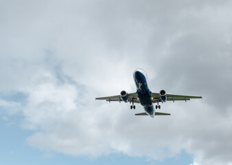 Background with a flying plane in the sky. Aircraft with landing gear in the sky. Travel concept with copy space