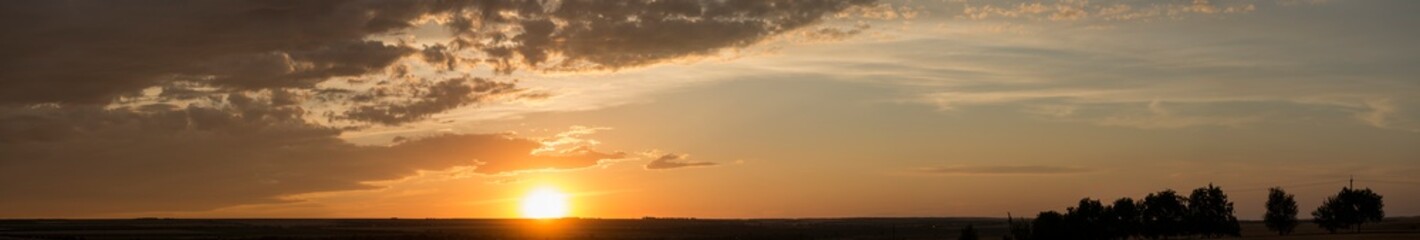 Landscape with bloody sunset. Panorama. Tragic gloomy sky. The last flashes of the sun on the storm...