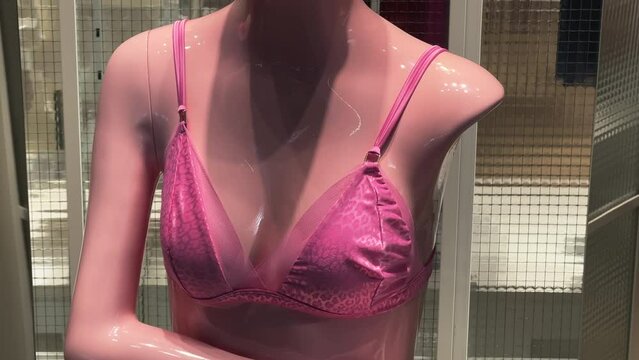 Pink bra worn on a woman's mannequin in a lingerie store window