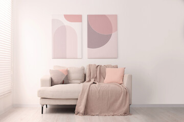 Cozy sofa with pillows and blanket in living room. Interior design