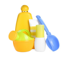 Different suntan products and plastic beach toys on white background