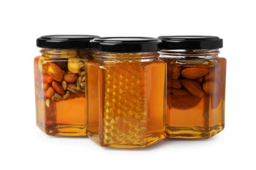 Jars with different nuts and honey on white background