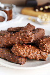 Tasty chocolate bars with caramel on white table, closeup